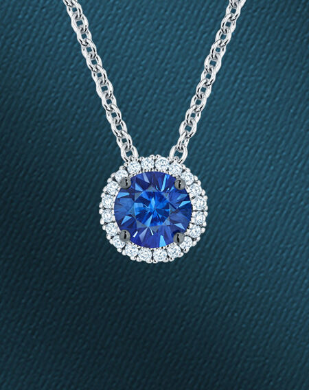 Birks sapphire and diamond necklace on a blue background.