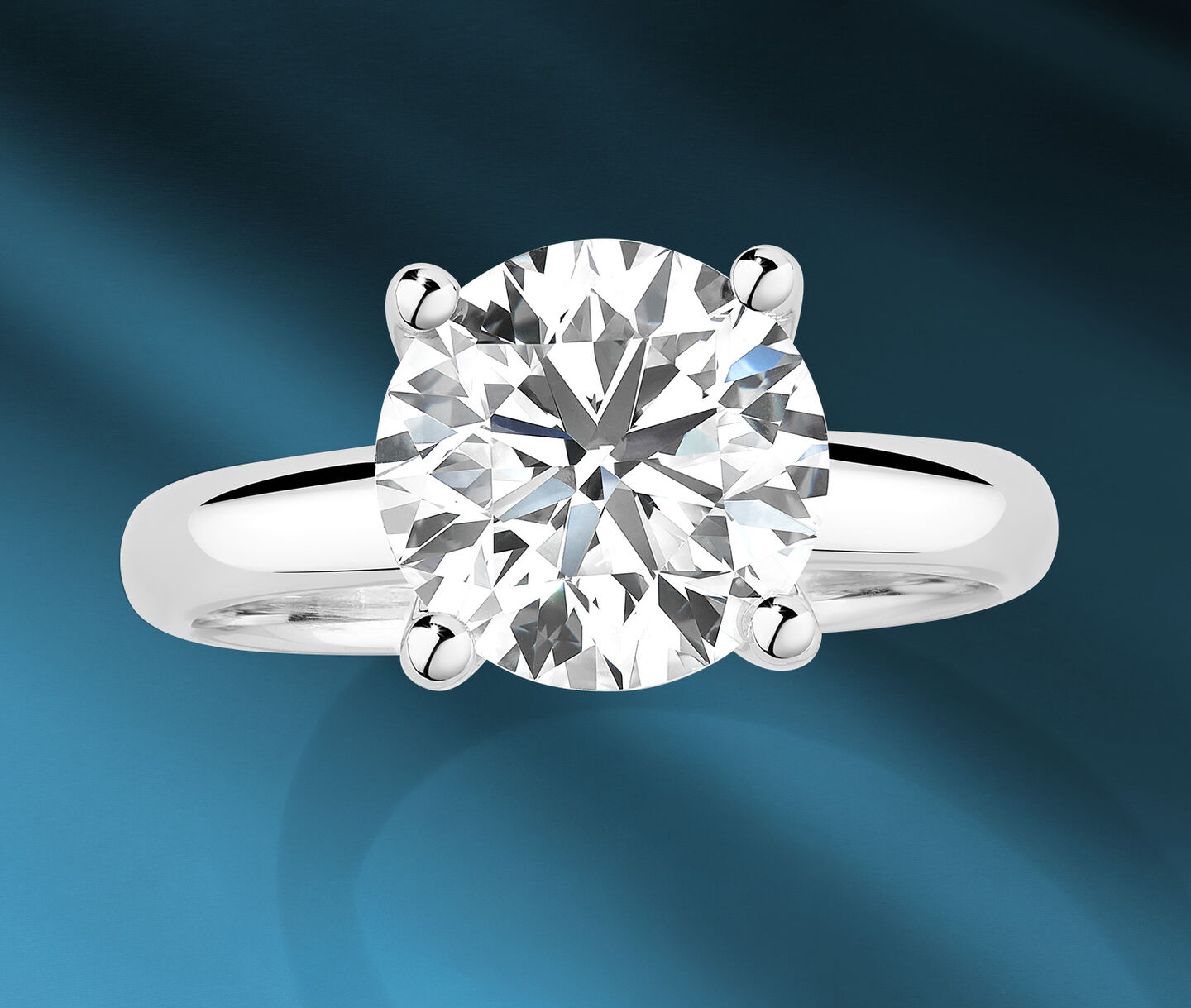 Birks 1879 diamond engagement ring on a blue background.