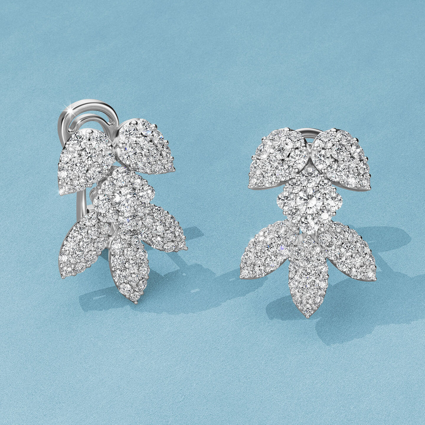 Boucles d'oreilles Birks Snowflake avec diamants sur un fond bleu.