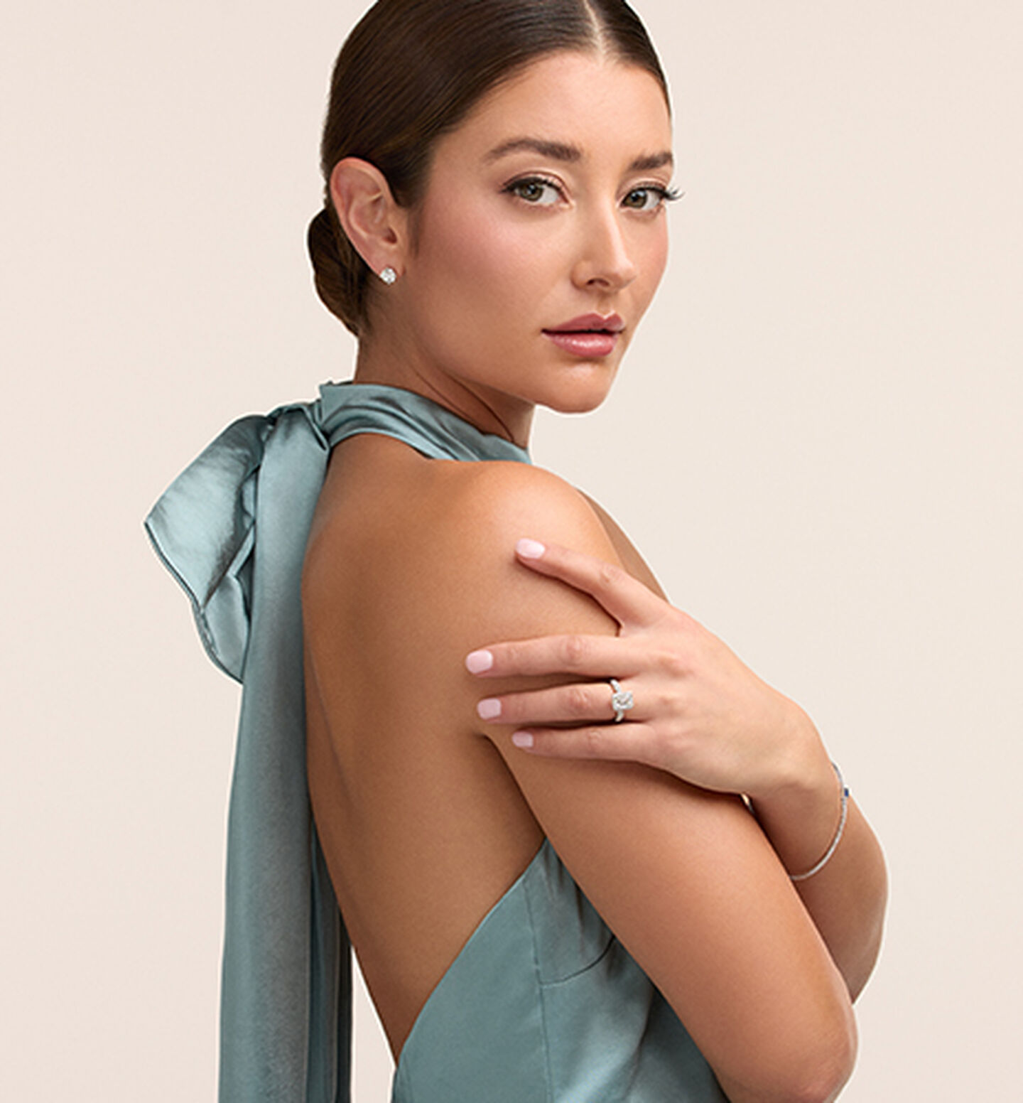 A woman wearing a Birks engagement ring and diamond jewellery.