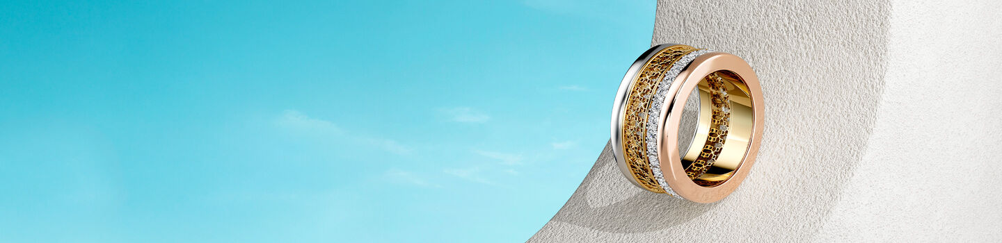 Birks Iconic stackable rings on a brown rock background.