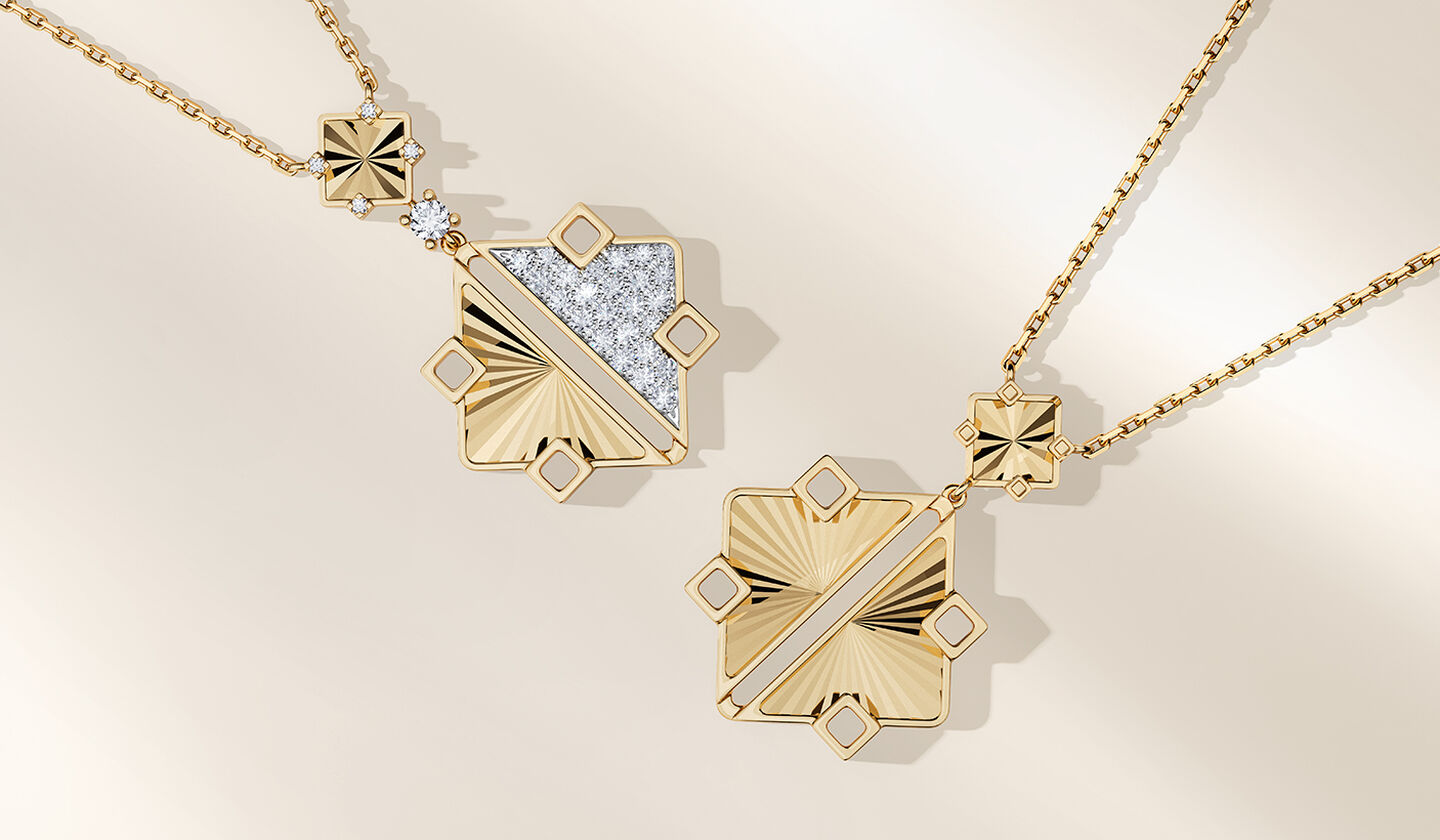 Deux colliers en or jaune et diamants Birks Muse sur un fond beige.