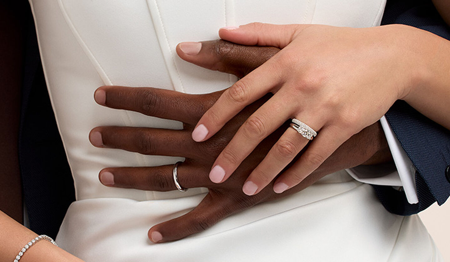 A closeup of a couple wearing Birks Bridal jewellery.