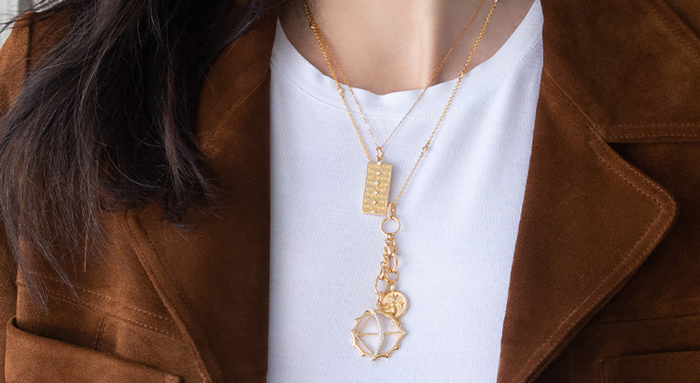 Model wears 3 gold pendant necklaces