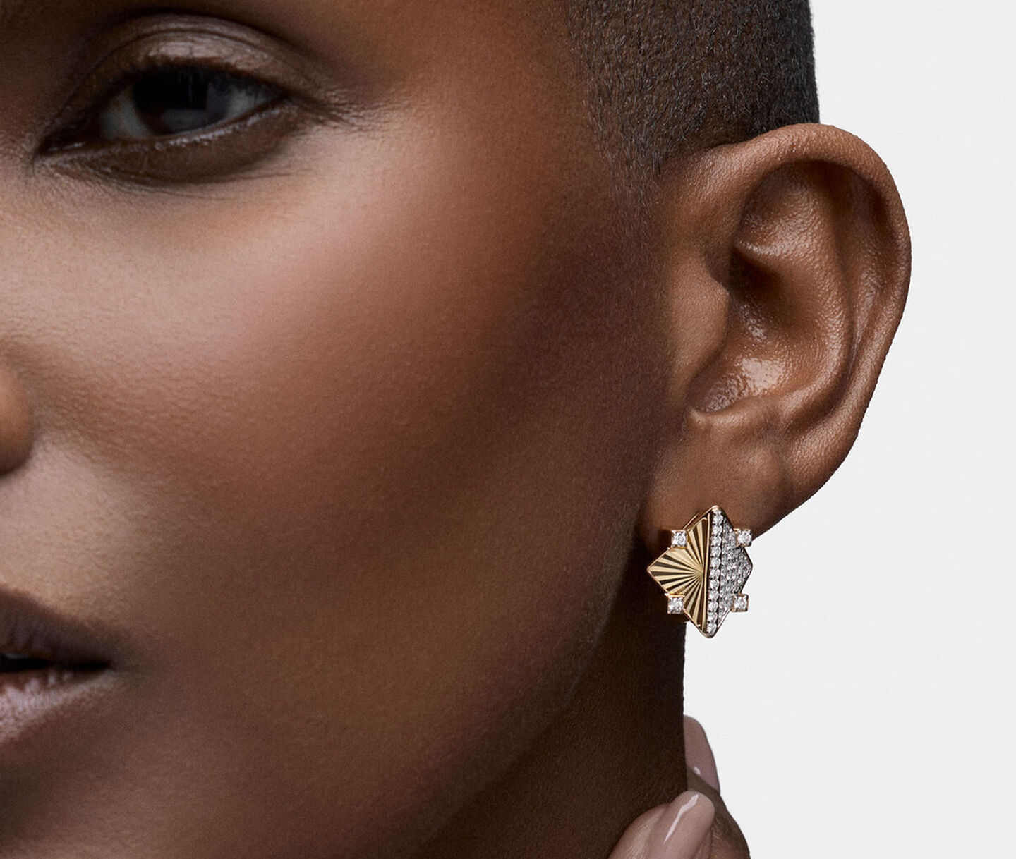 A woman wearing the Birks Muse gold and diamond earrings.