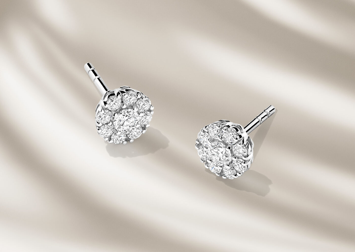 Boucles d'oreilles Birks Snowflake sur un fond beige.