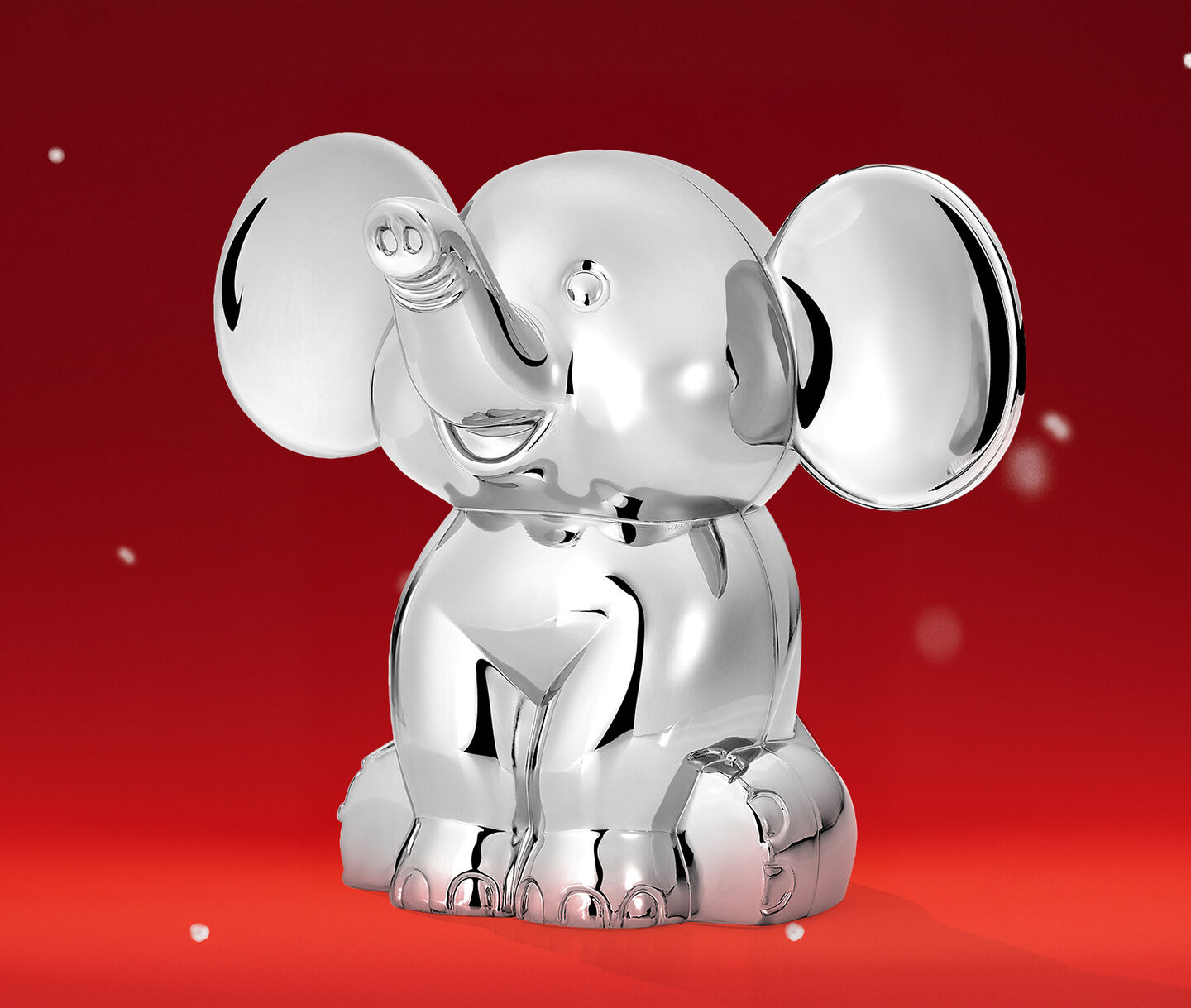 Maison Birks elephant coin bank on a red holiday background.