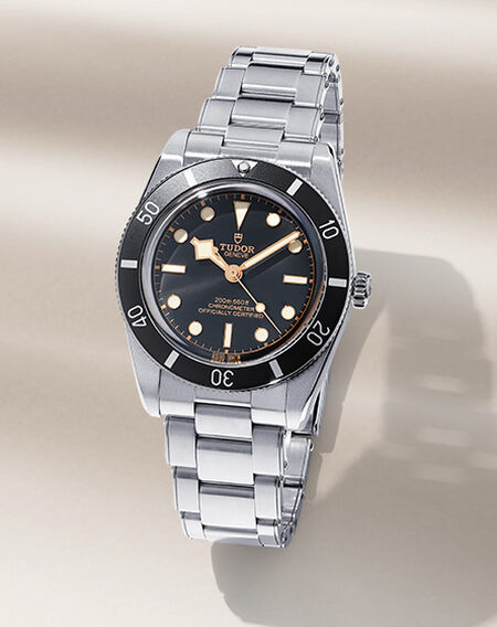 Montre TUDOR Black Bay sur un fond beige.