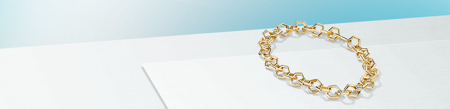 Birks Bee Chic yellow gold chain bracelet on a light blue background