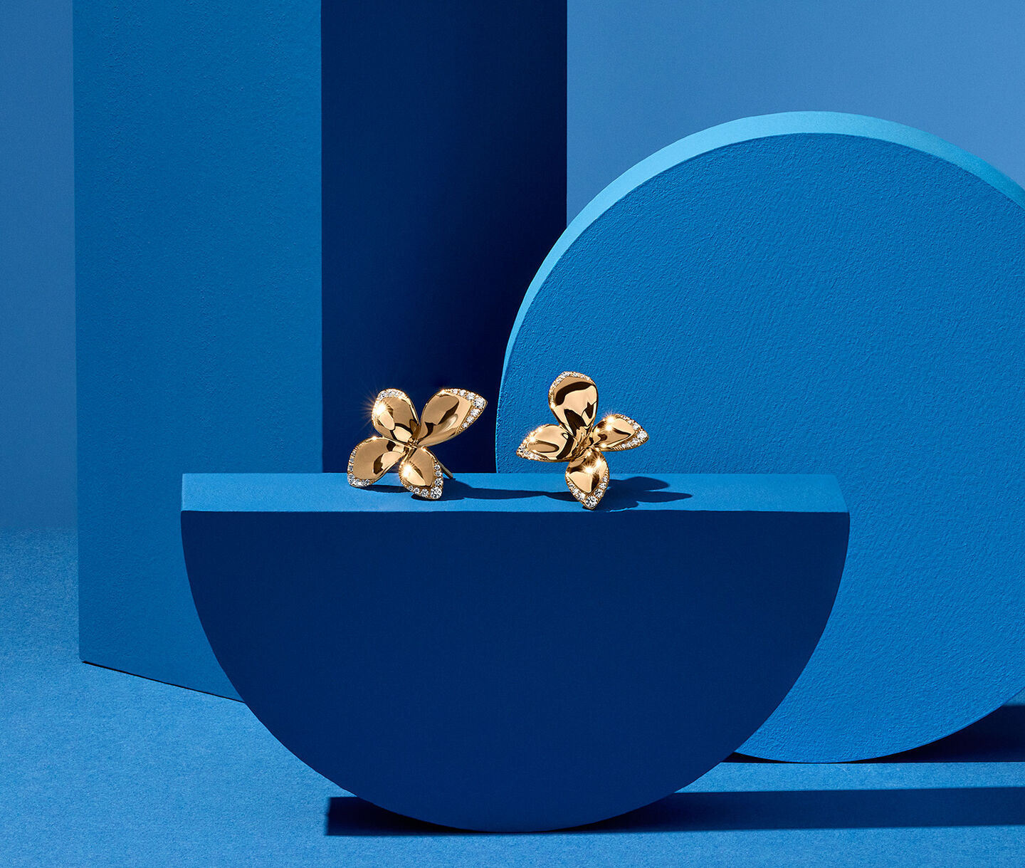Pasquale Bruni Giardini Segreti earrings on a blue background.