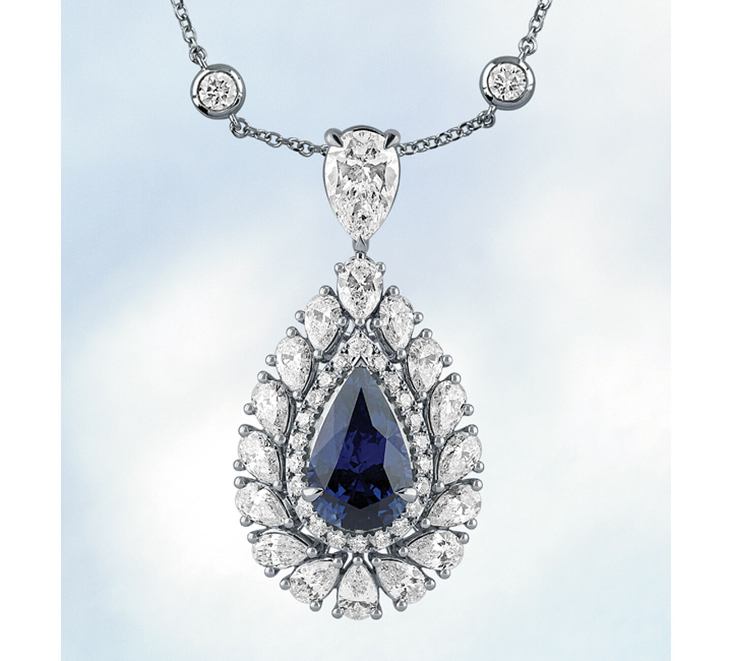 Le collier Birks Pure Desire en saphir et diamant sur un fond bleu.