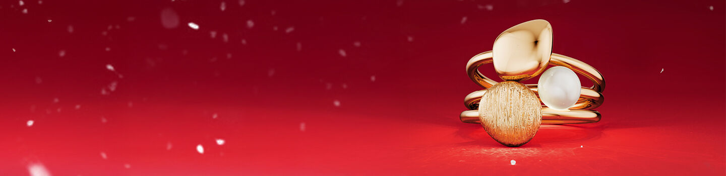  Galet et perle Birks sur un fond rouge.