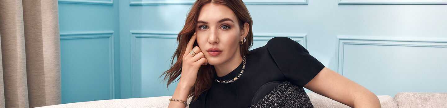Sophie Nelisse wearing the Birks Dare to Dream jewellery collection on a blue background.