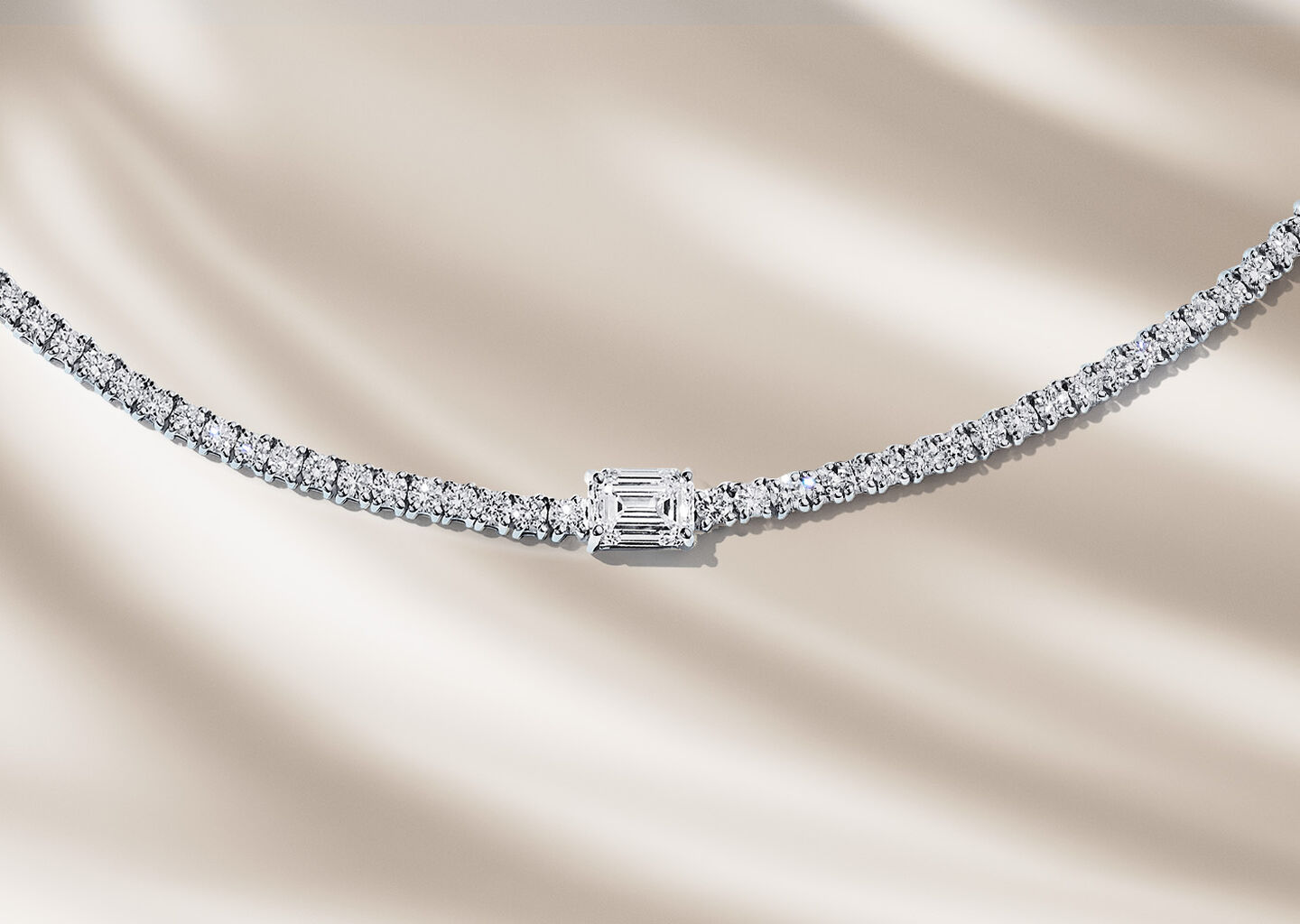 Birks Essentials diamond necklace on a beige background.
