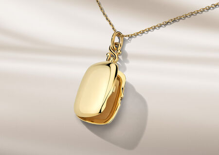 Collier Monica Rich Kosann en or jaune sur un fond beige.