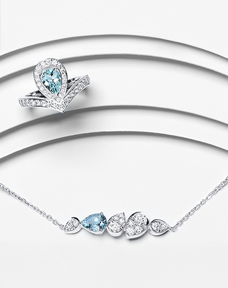 A Chaumet Joséphine aquamarine ring and necklace on a white layered background.