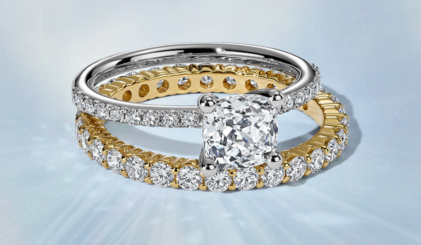 A Birks Rosee Du Matin Diamond Engagement and Eternity yellow gold diamond Ring on a blue background.