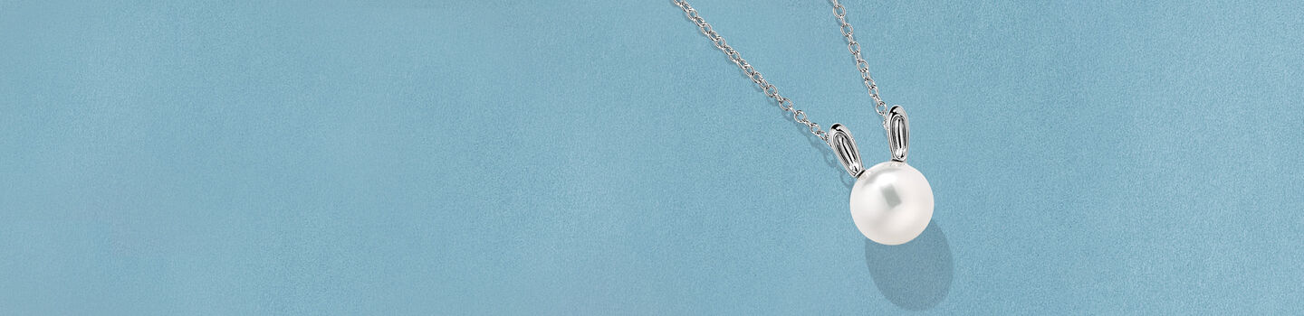 Pendentif avec perle Birks Essentiels sur un fond bleu.