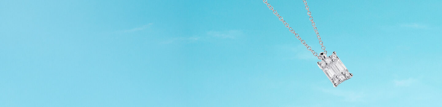 Birks Essentials diamond necklace on a blue background.