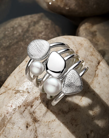 Bague empilable Birks Pebble sur fond de galets gris plats