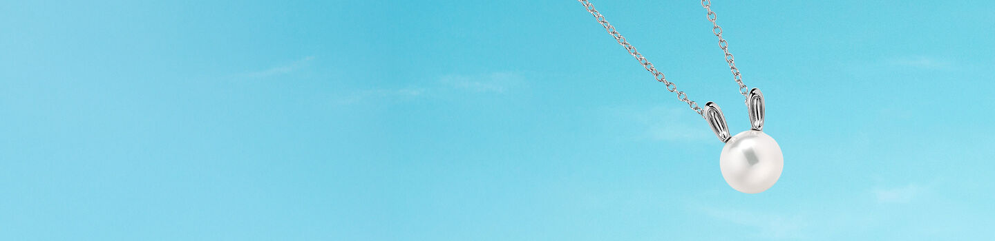 Collier en argent et perle Birks Essentiels sur fond bleu de ciel.