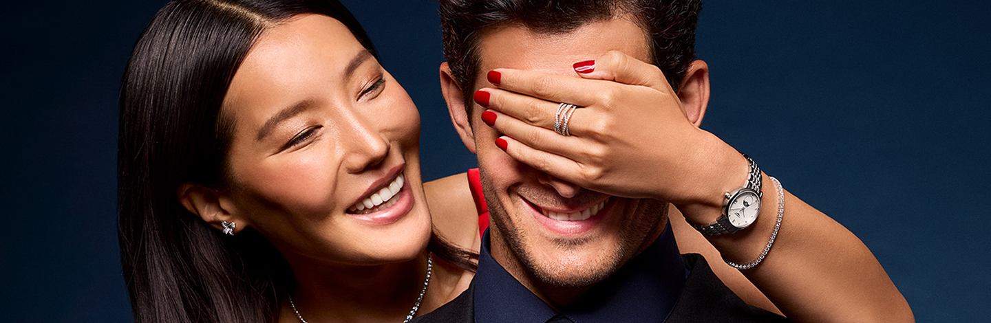 A couple celebrating the holidays wearing Maison Birks jewellery and watches.