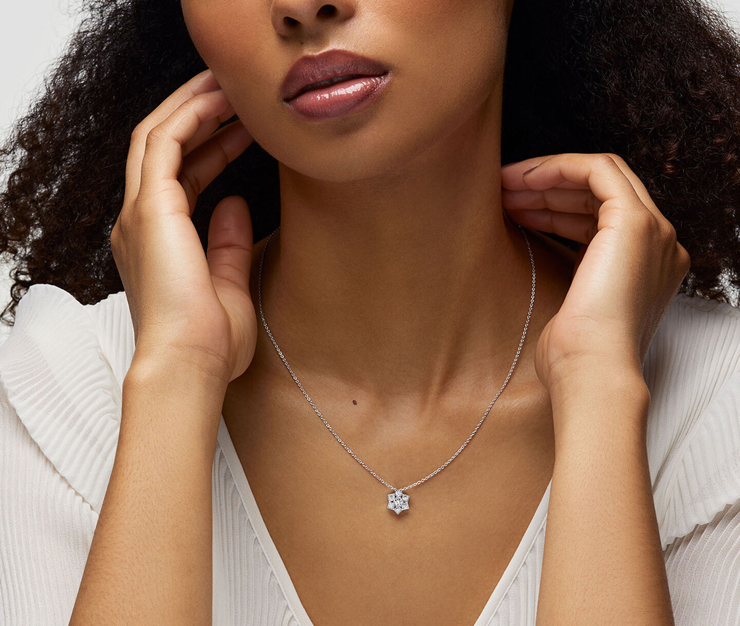 A woman wearing a Birks Snowflake diamond necklace.