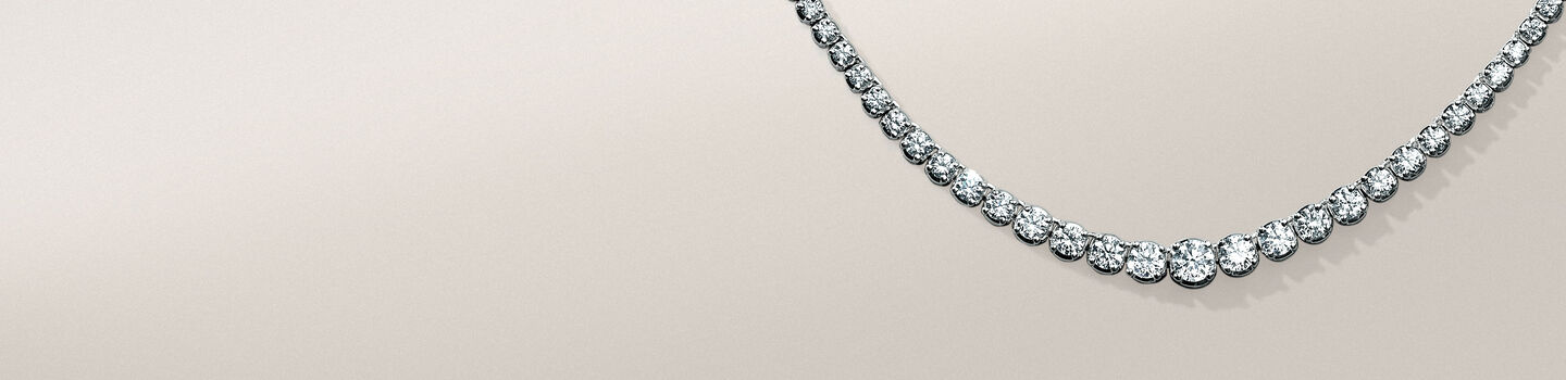 Birks Essentials diamond riviera necklace on a greyish-beige background