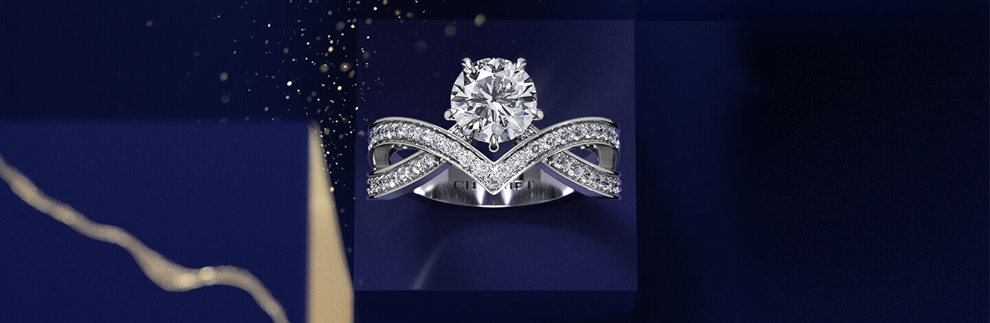 Une bague de fiançaille à diamant Joséphine de Chaumet sur un fond bleu foncé .