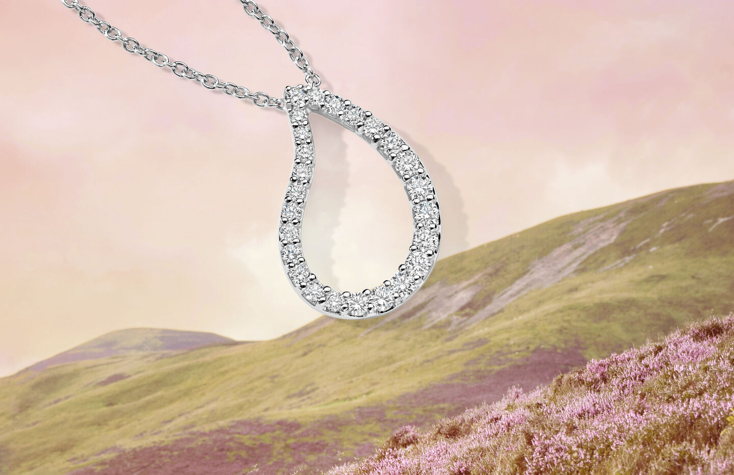 Birks Pétale white gold and diamond pendant on a background of nature.