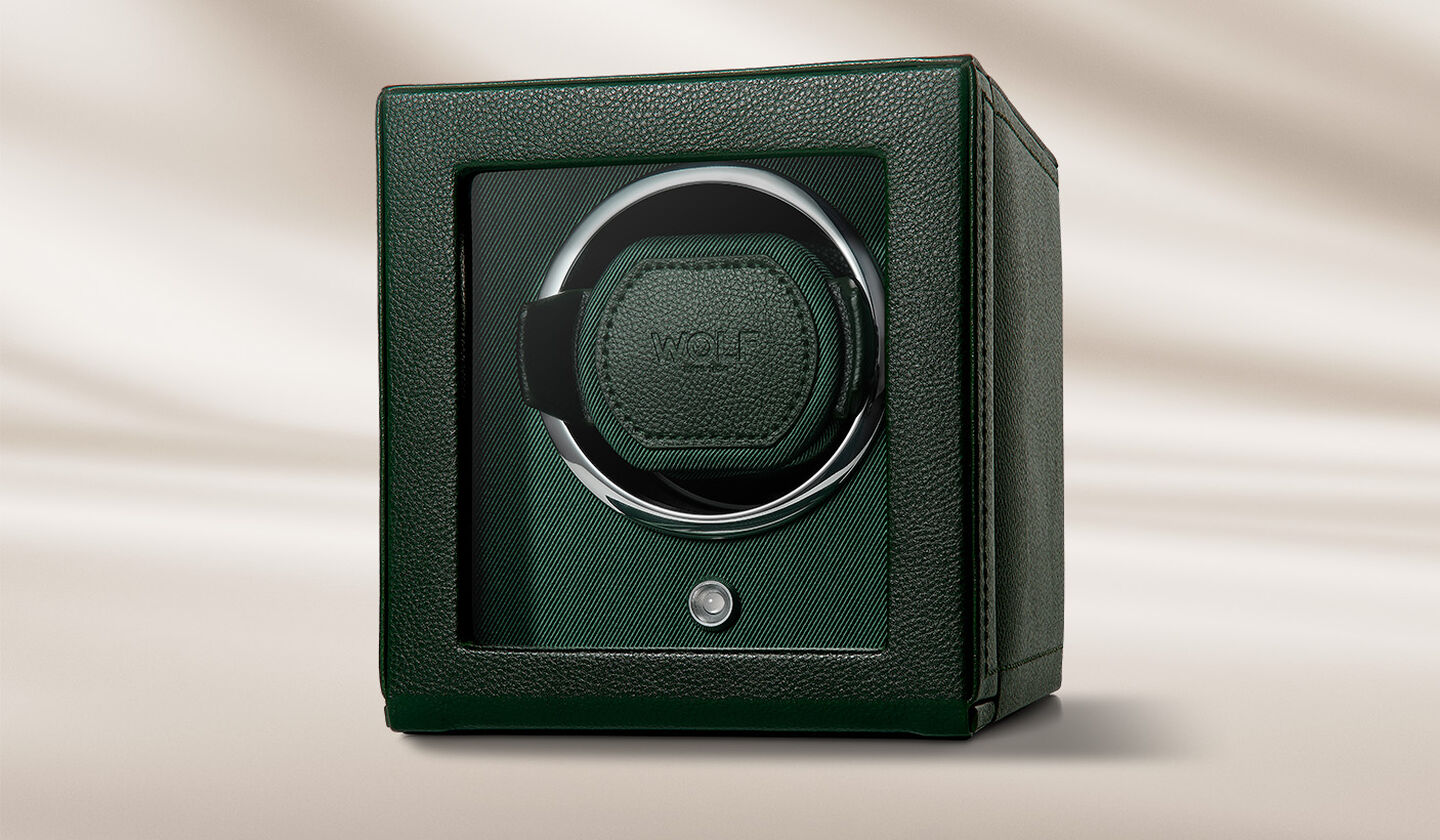 A leather WOLF watch winder on a beige background.