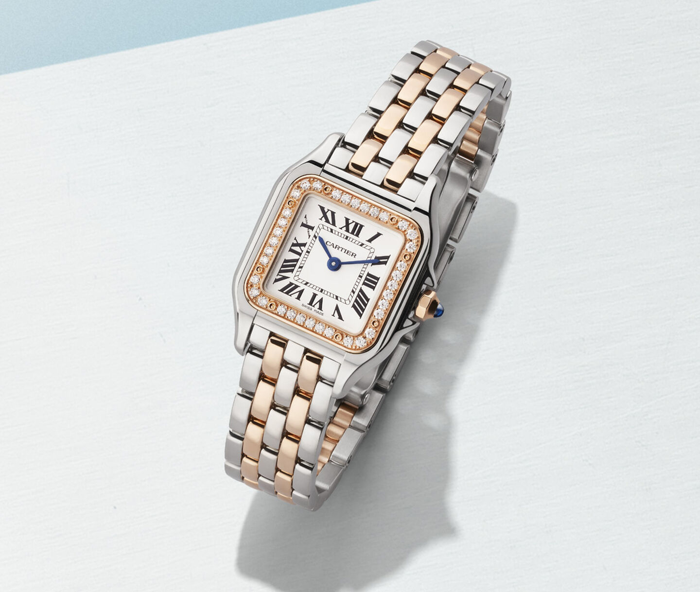 Montre Panthère de Cartier pour femmes sur un fond bleu. 