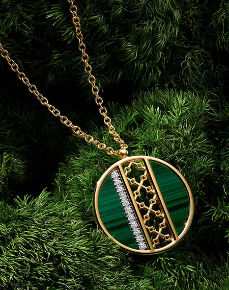Birks Dare to Dream malachite necklace on a green grass background.