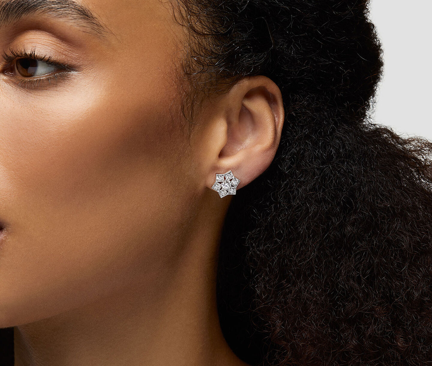 Une femme porte les boucles d'oreilles avec diamants Birks.