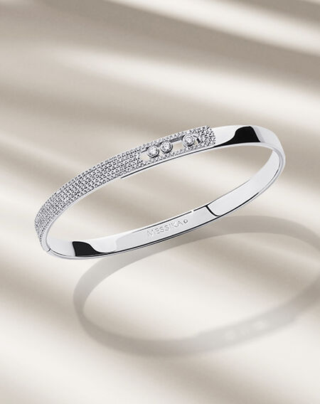 Bracelet Move Noa de Messika sur un fond beige.
