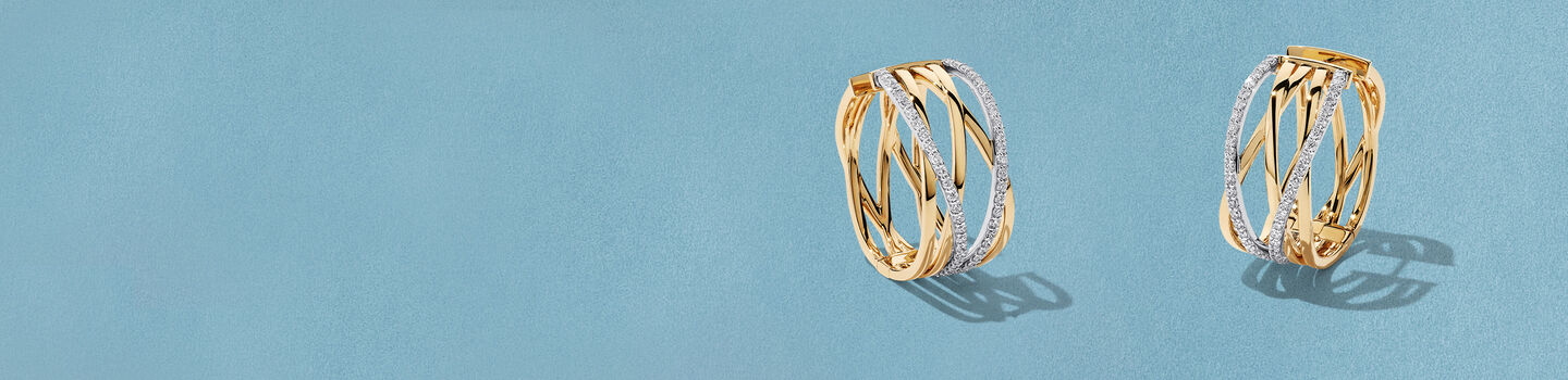 Birks Rosee du Matin diamond and gold earrings on a blue background