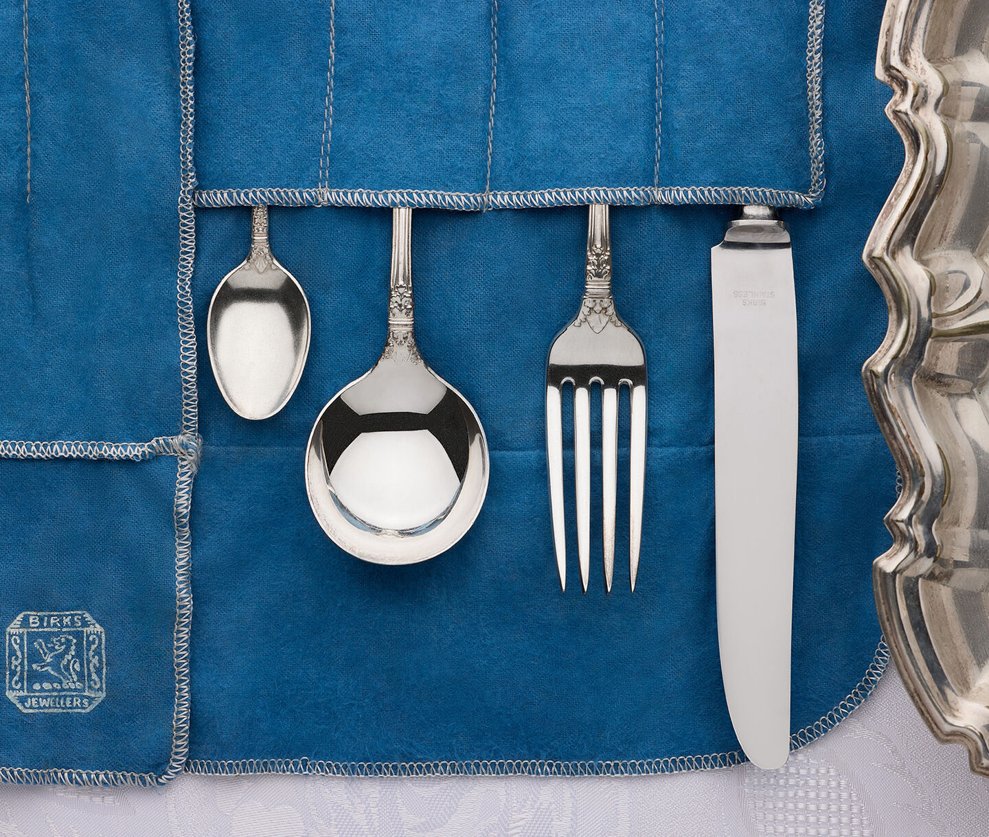 Vintage Birks silverware set arranged on a blue heirloom cloth for family celebrations