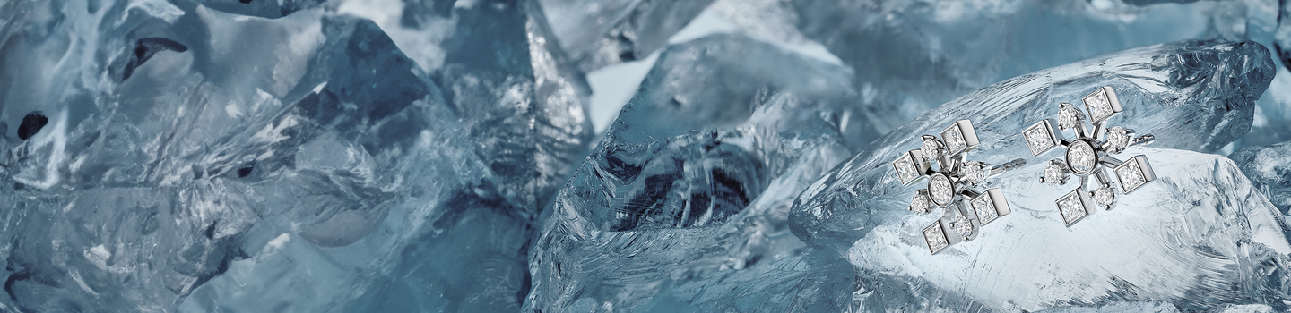 Boucles d'oreilles Birks Snowflake sur fond bleu glacier.