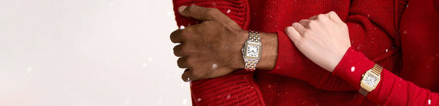 A couple in a red sweater wearing Cartier watches.