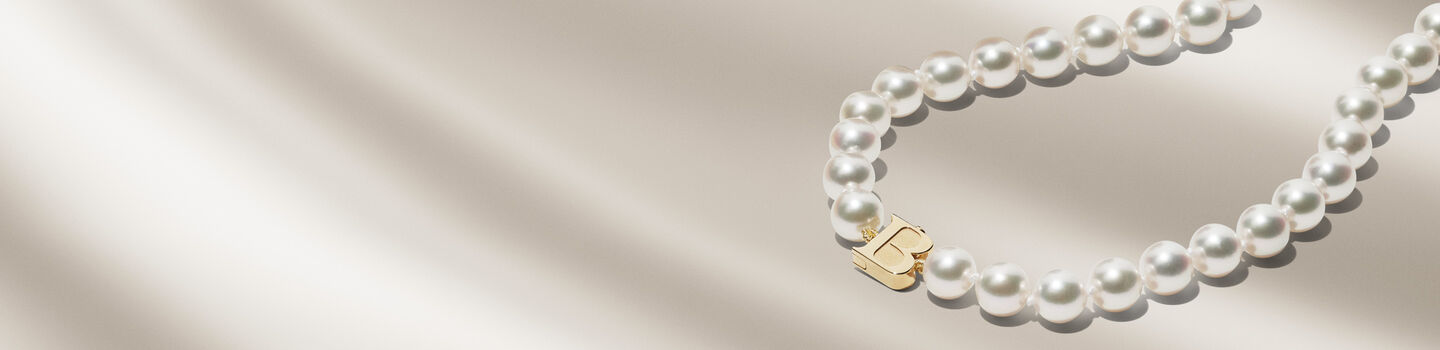 Birks Pearls Akoya pearl necklace on a beige background.