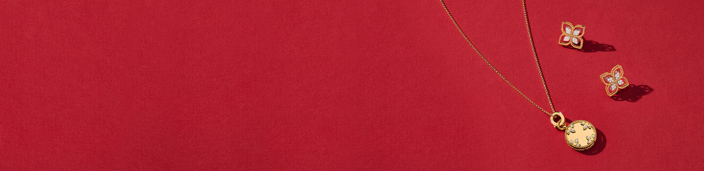 Roberto Coin yellow gold jewellery on a red background.
