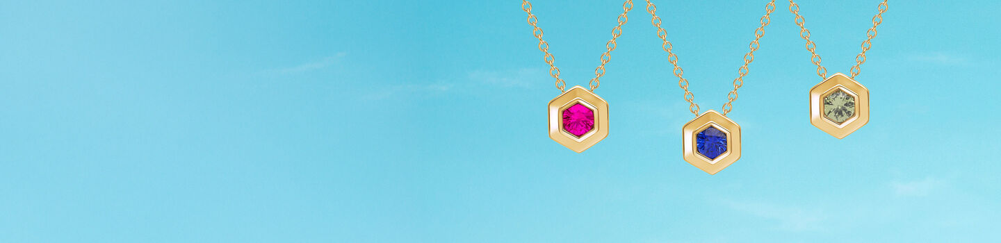 Collier en argent Birks Bee Chic ao&ucirc;t, septembre, et octobre en or jaune sur un fond bleu.