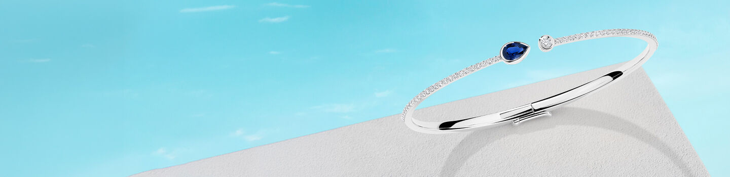 Birks Splash Sapphire diamond bangle on a blue background.
