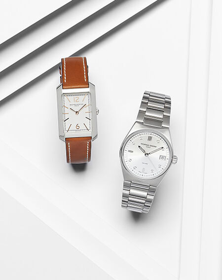 A Baume & Mercier Hampton watch and Frederique Constant watch for women on a white layered background. 