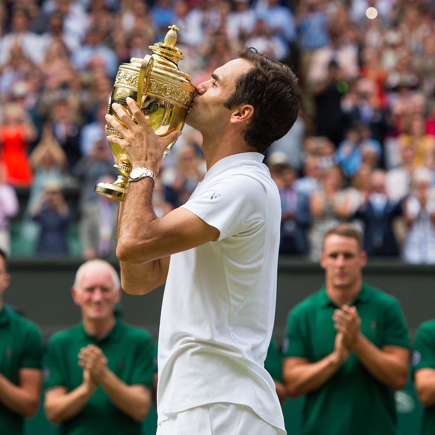Man kisses a gold trophy
