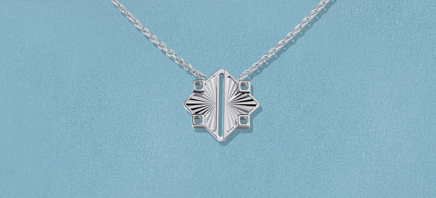 Pendentif Birks Muse sur un fond bleu.