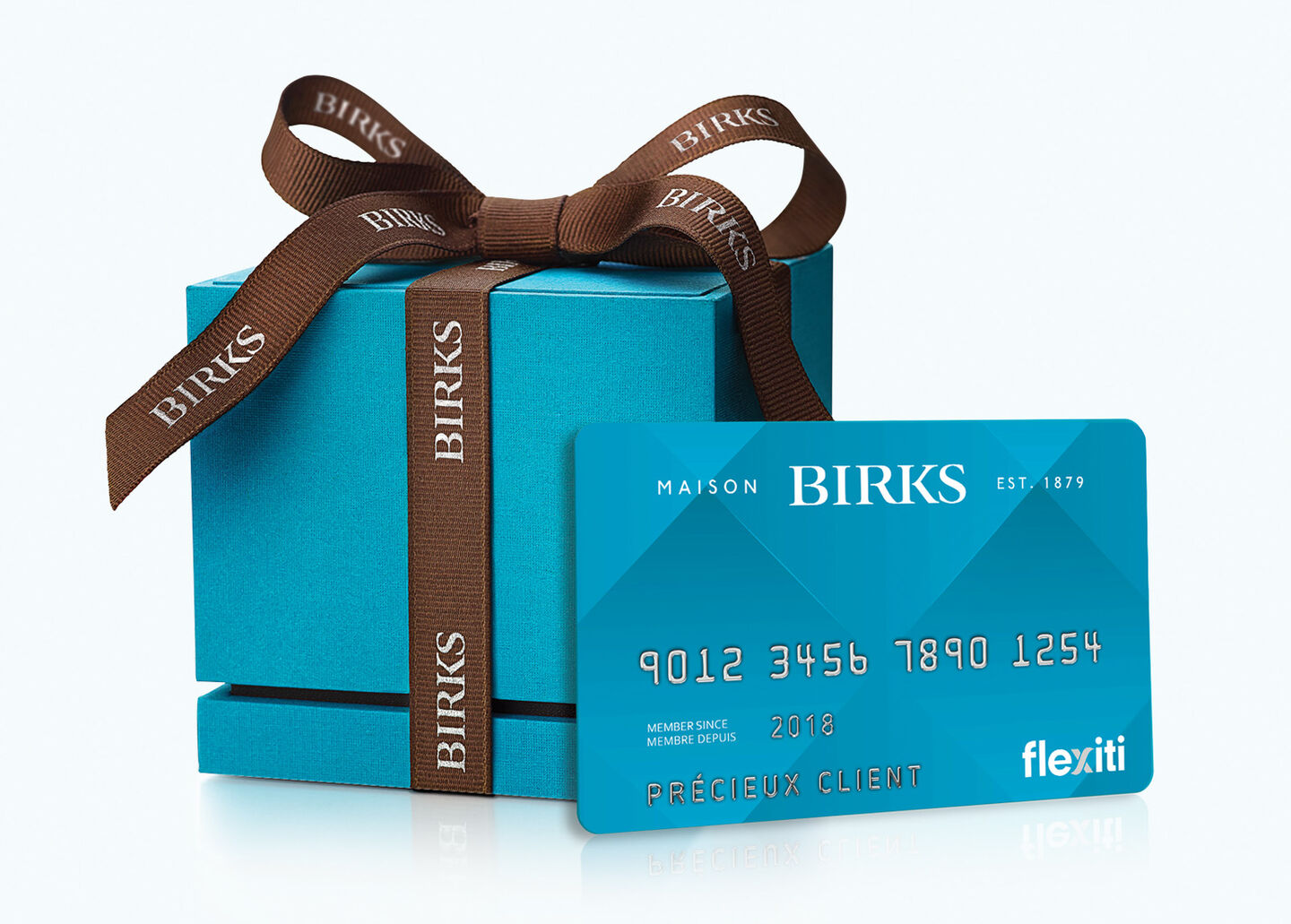 Une boîte bleu de Birks avec une carte Maison Birks Flexiti sur un fond bleu.