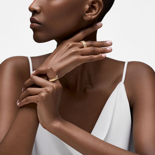 On-model view of Birks Essentials yellow gold pleated rings in 5 and 8 mm worn on the finger image number 2