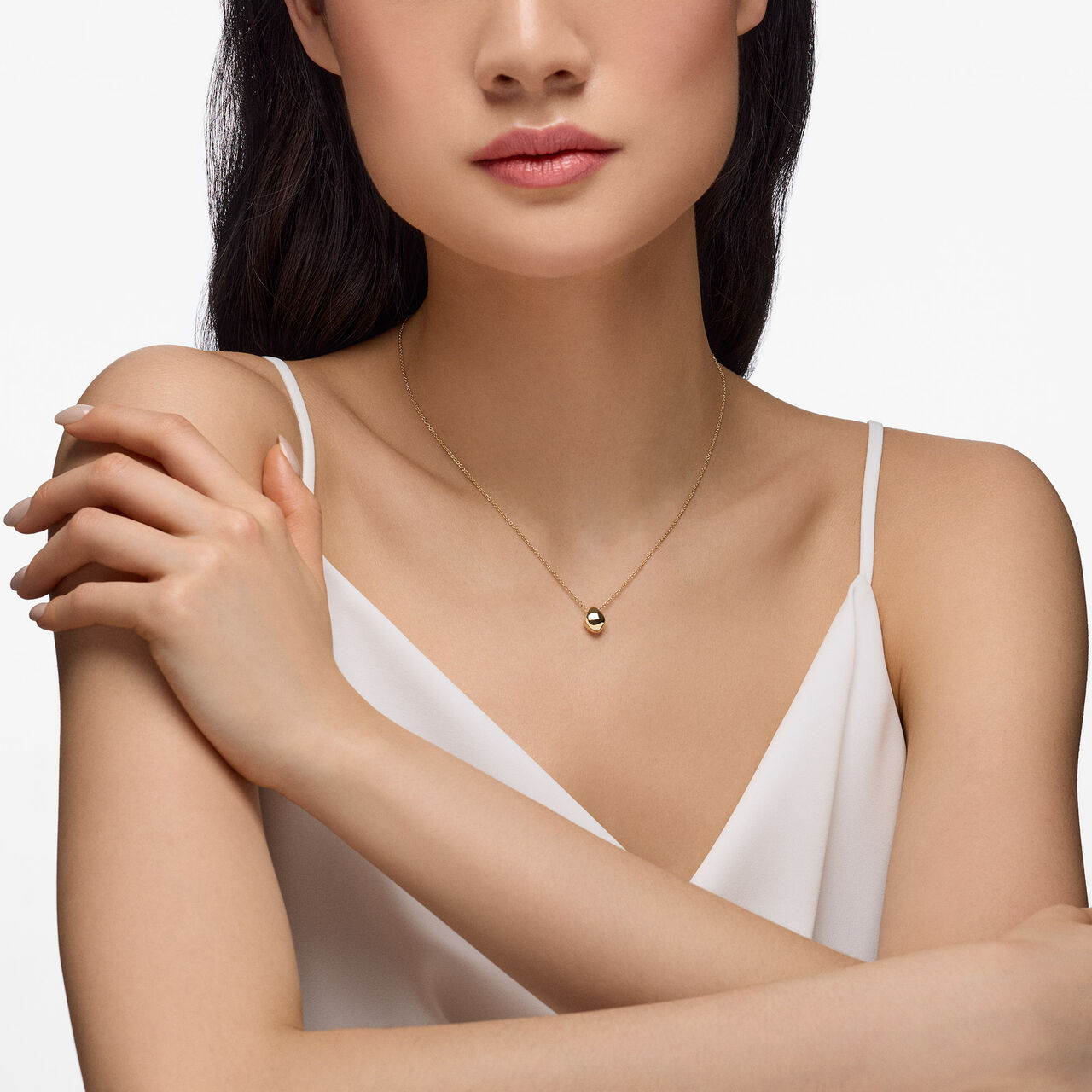 On-model view of Birks Pebble yellow gold pendant worn on the neck image number 1