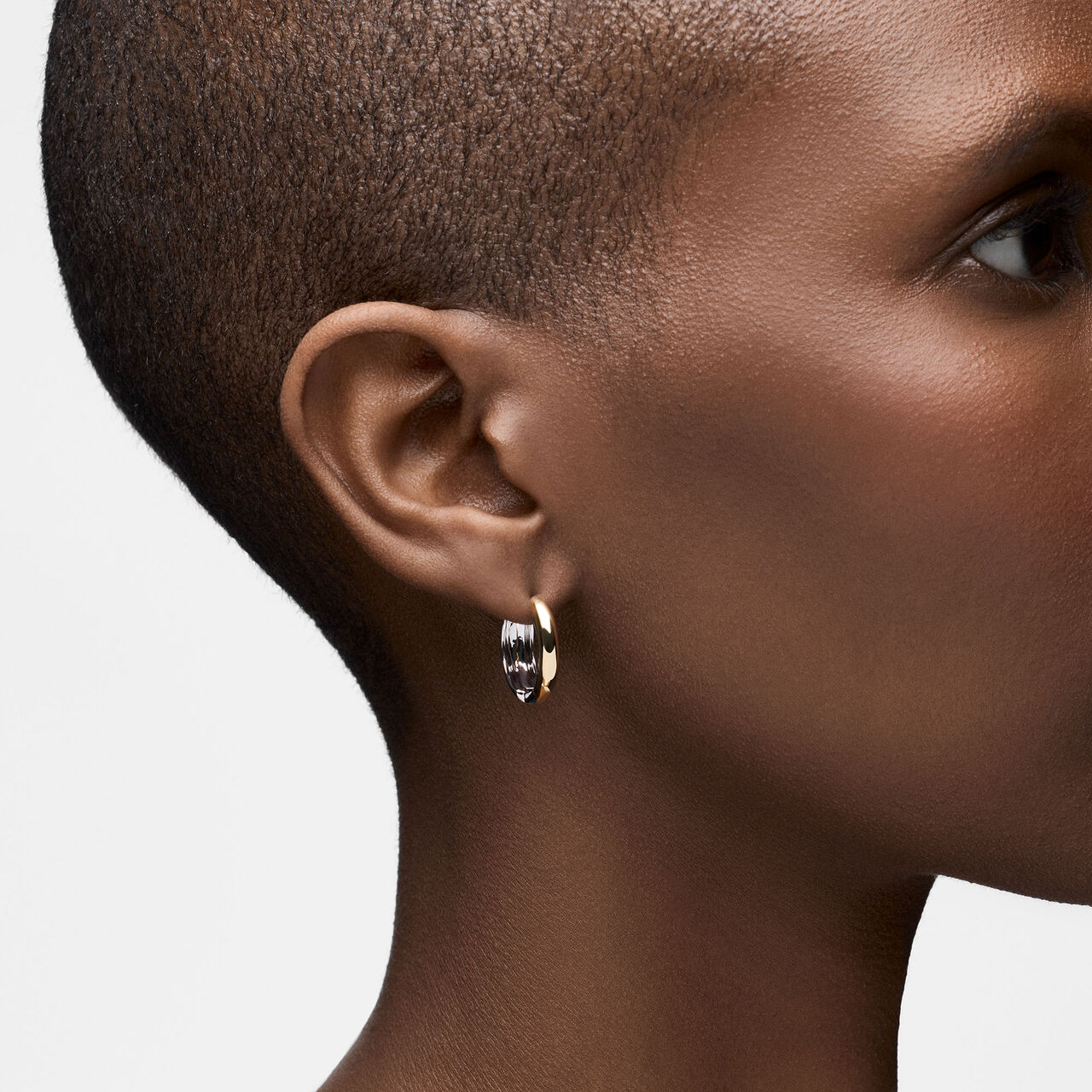 On-model view of Birks Essentials reversed yellow and white gold hoops worn on the ear image number 2